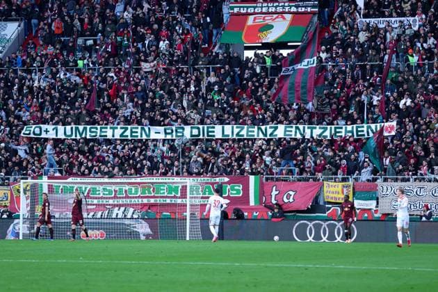 Soccer 1 Bundesliga 8 Matchday FC Augsburg RB Leipzig on 25 10 2025 at the WWK Arena in Augsburg Banner in the FC Augsburg fan block with the inscription 50 1 UMSETZTEN RB DIE LIZENZ ENTZIEHEN DFL regulations prohibit any use of photographs as image sequences and or quasi video xMSx