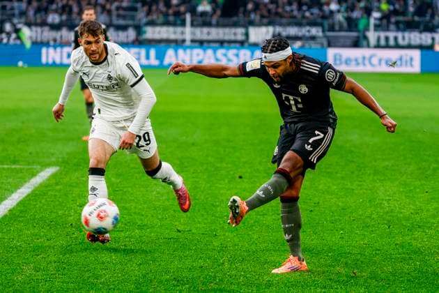 Serge Gnabry of FC Bayern München dribbles with the ball under pressure from Joe Scally of Borussia Mönchengladbach Borussia Mönchengladbach v FC Bayern München, Bundesliga, Borussia Mönchengladbach v FC Bayern München, Stadion im Borussia-Park, October 25, 2025, Mönchengladbach, Germany.