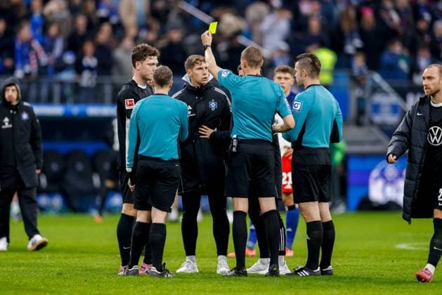 Hamburg, October 25, 2025 Soccer, 1 Bundesliga 2025 26, Hamburger SV VfL Wolfsburg Referee Martin Petersen shows Loic Fave Hamburger SV, Co Trainer the yellow card after the final whistle DFL REGULATIONS PROHIBIT ANY USE OF PHOTOGRAPHS AS IMAGE SEQUENCES AND OR QUASI VIDEO