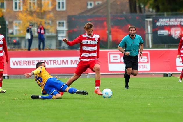 Picture from left Justin Schau 25 FC Carl Zeiss Jena vs Theo Harz 33 Greifswalder FC Regionalliga Nordost Greifswalder FC red vs FC Carl Zeiss Jena yellow 25 10 2025 in Greifswald