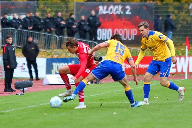 Picture from left Joe Joe Richardson 10 Greifswalder FC vs Marcel Hoppe 15 FC Carl Zeiss Jena Regionalliga Nordost Greifswalder FC red vs FC Carl Zeiss Jena yellow 25 10 2025 in Greifswald
