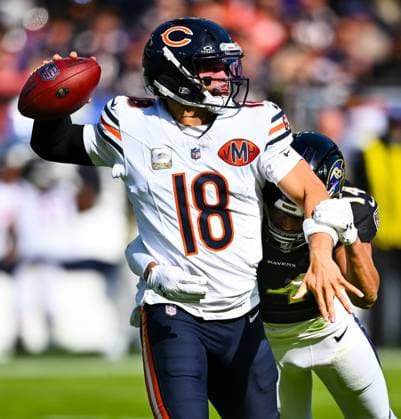 Chicago Bears quarterback Caleb Williams (18) is pressured by Baltimore Ravens safety Kyle Hamilton (14) before he incurs a penalty for intentional grounding during the second quarter at M&T Bank Stadium in Baltimore, Maryland, on Sunday, October 26, 2025.  BAL20251026107 DAVIDxTULIS
