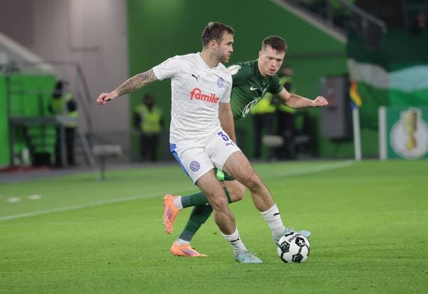 Marco Komenda Holstein Kiel , Dzenan Pejcinovic VfL Wolfsburg Fußball, Saison 2025 2026, Maenner, Herren, DFB Pokal, 2 Hauptrunde, Volkswagenarena Wolfsburg, VfL Wolfsburg vs Holstein Kiel DFL REGULATIONS PROHIBIT ANY USE OF PHOTOGRAPHS AS IMAGE SEQUENCES AND OR QUASI VIDEO