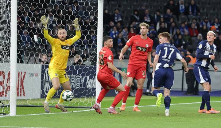Sebastian Grönning scores the goal for 2 0 against goalkeeper Nicolas Kristof duel Match scene Action Sport Soccer Football DFB Pokal 2 Round Men Season 2025 2026 28 10 2025 Hertha BSC Berlin vs SV Elversberg DFL regulations prohibit any use of photographs as image sequences and or quasi video
