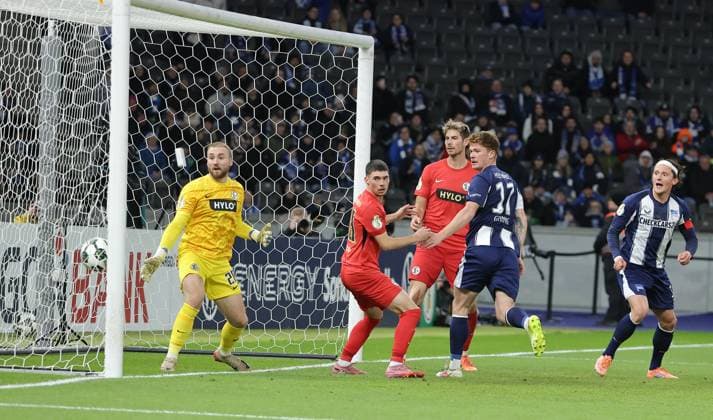 Sebastian Grönning scores the goal for 2 0 against goalkeeper Nicolas Kristof duel Match scene Action Sport Soccer Football DFB Pokal 2 Round Men Season 2025 2026 28 10 2025 Hertha BSC Berlin vs SV Elversberg DFL regulations prohibit any use of photographs as image sequences and or quasi video