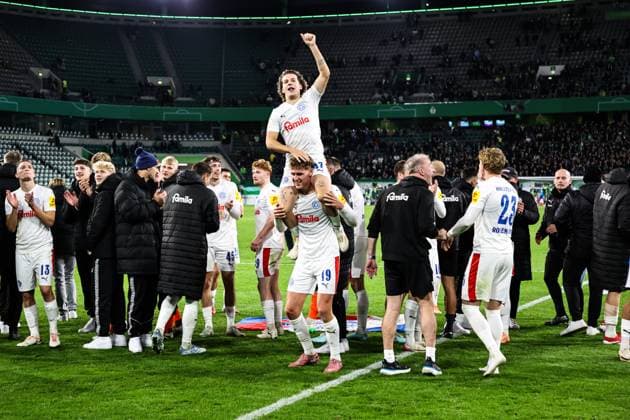 John Tolkin Holstein Kiel,47 and Phil Harres Holstein Kiel,19 The team of Holstein Kiel celebrates the victory in front of the fan block 2 round DFB Pokal season 2025 2026 VfL Wolfsburg vs Holstein Kiel at the Volkswagen Arena in Wolfsburg action,football,Germany,man,men,28 10 2025