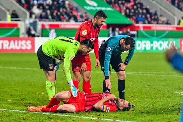 GER, DFB Pokal, 1 FC Heidenheim vs Hamburger SV 28 10 2025, Voith Arena, Heidenheim, GER, DFB Pokal, 1 FC Heidenheim vs Hamburger SV, in the picture Diant Ramaj Heidenheim, 41 , Marnon Busch Heidenheim, 2 , referee Benjamin Brand, Patrick Mainka Heidenheim, 6 lies dazed on the pitch nordphotoxGmbHx xHafner nph00200