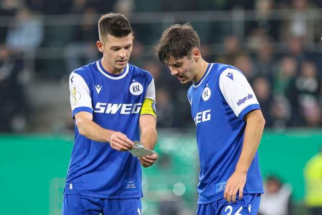Mönchengladbach, Germany, 28 10 25 Marvin Wanitzek Karlsruher SC and Rafael Pinto Pedrosa Karlsruher SC read a note during the DFB Pokal 2 round match between Borussia Mönchengladbach vs Karlsruher SC at the stadium in Borussia Park Mönchengladbach Stadion im Borussia Park North Rhine Westphalia Germany Copyright: xBrauer-Fotoagenturx xAdrianxSchlx