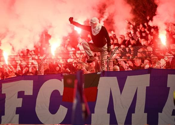 Soccer DFB Cup 2025 2026 2 round 29 10 2025 FV Illertissen 1 FC Magdeburg The Utras 1 FC Magdeburg cheer with pyros in the Gaestefanblock after the goal to 0 1 a hooded fan sits on the fence