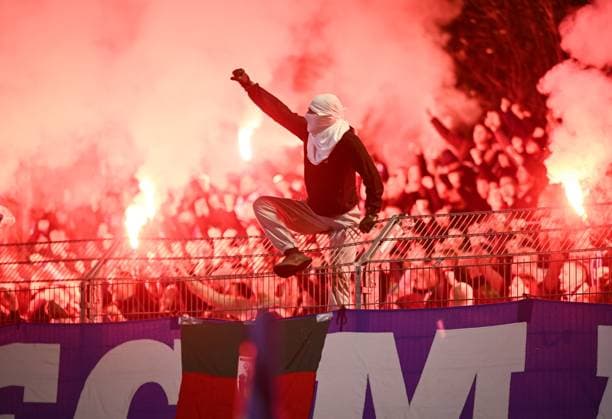 Soccer DFB Cup 2025 2026 2 round 29 10 2025 FV Illertissen 1 FC Magdeburg The Utras 1 FC Magdeburg cheer with pyros in the Gaestefanblock after the goal to 0 1 a hooded fan sits on the fence