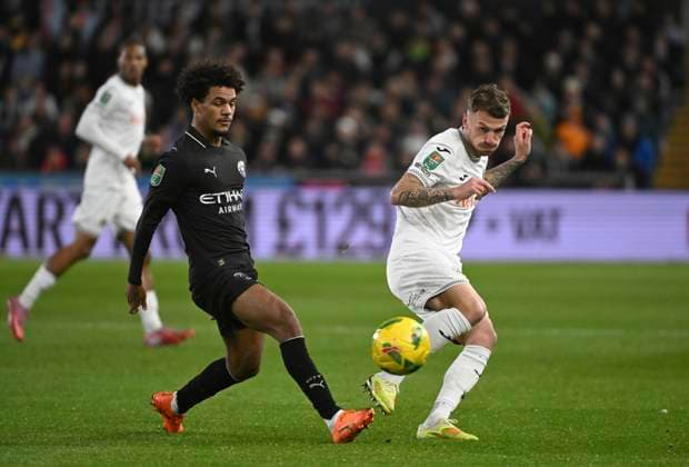 29th October 2025; Swansea.com Stadium, Swansea, Wales; EFL Carabao Cup Football, Swansea City versus Manchester City; Josh Tymon of Swansea City FC plays the ball into space in front of Oscar Bobb of Manchester City FC  AledxHopkins
