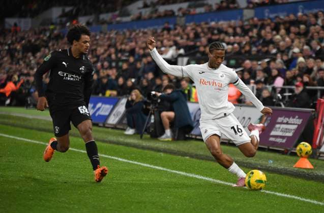 29th October 2025; Swansea.com Stadium, Swansea, Wales; EFL Carabao Cup Football, Swansea City versus Manchester City; Ishe Samuels-Smith of Swansea City FC keeps the ball in play in front of Oscar Bobb of Manchester City FC  AledxHopkins