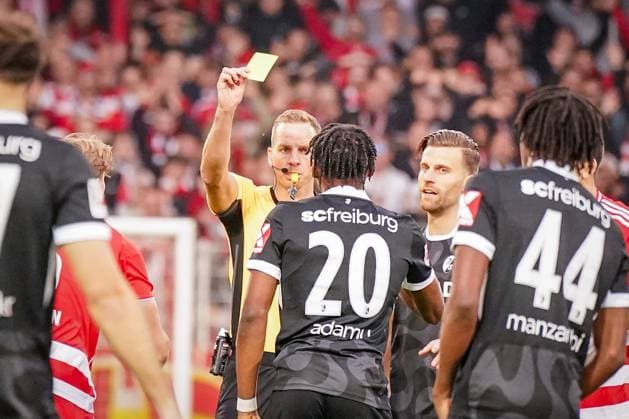 Germany Soccer Bundesliga 2025 26, 9 Matchday 1 FC Union Berlin vs SC Freiburg An der Alten Försterei Berlin Referee Sören Storks shows Junior Adamu SC Freiburg, 20 yellow card Berlin Germany Copyright: xJOERANxSTEINSIEKx