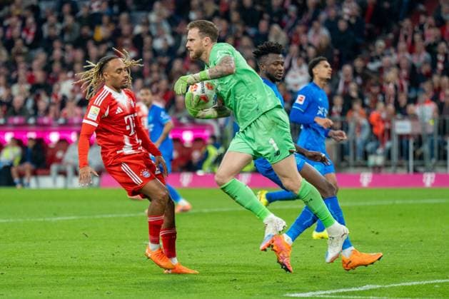 in duel, action, with Sascha Boey 23 FC Bayern Muenchen , Mark Flekken 1 Bayer 04 Leverkusen , FC Bayern Muenchen vs Bayer 04 Leverkusen, Football, 1 Bundesliga, 9 Matchday, 01 11 2025 DFB regulations prohibit any use of photographs as image sequences and or quasi video Muenchen Bayern Germany Copyright: xkolbert-press MarcxMarasescux