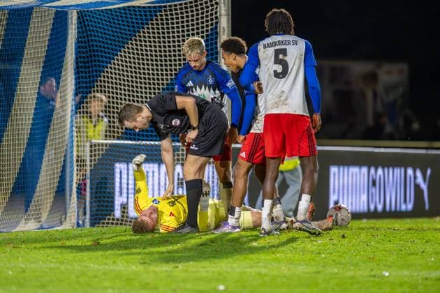 Soccer, Regionalliga Nord, BW Lohne Hamburger SV II , 17 Matchday, Season 2025 2026, 1 11 2025 Timon Kramer Hamburger SV II 20 with Arnaud Riedel Hamburger SV II 21 and Shafiq Nandja Hamburger SV II 5 at the injured Hannes Herrmann Goalkeeper Hamburger SV II 1 who lies injured on the ground after holding the penalty kick , Lohne Heinz Dettmer Stadion Niedersachsen Germany