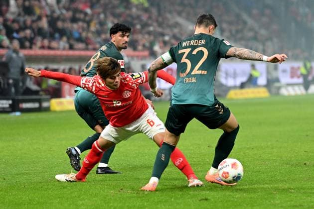 Kaishu SANO MZ against Cameron PUERTAS HB and Marco FRIEDL HB Action, duel, 1 FSV Mainz 05 MZ SV Werder Bremen HB 1 1 Football 1 Bundesliga Season 2025 2026, 9 Matchday, Spieltag9, matchday9, am 01 11 2025, MEWA Arena Mainz DFL regulations prohibit any use of photographs as image sequences and or quasi video Â