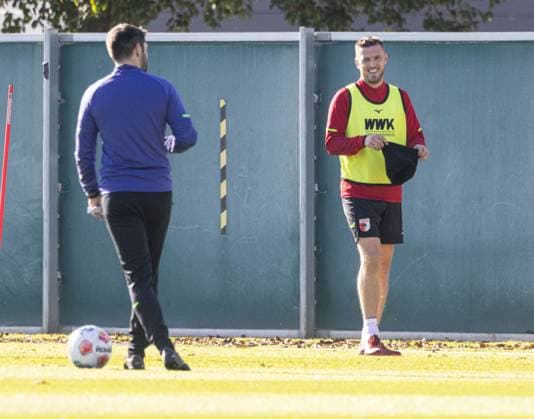 Jeffrey Gouweleeuw FC Augsburg 6 is back on the training pitch after injury, in a good mood with cap and with Sven Palinkasch Co Coach FC Augsburg FC Augsburg, training,