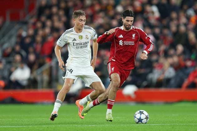 Liverpool, England, 4th November 2025. Dominik Szoboszlai of Liverpool and Dean Huijsen of Real Madrid during the Liverpool vs Real Madrid UEFA Champions League match at Anfield, Liverpool. Picture credit should read: James Baylis Sportimage EDITORIAL USE ONLY. No use with unauthorised audio, video, data, fixture lists, club league logos or live services. Online in-match use limited to 120 images, no video emulation. No use in betting, games or single club league player publications. SPI_116_JB_LIVERPOOL_REAL_MADRID SPI-4264-0115