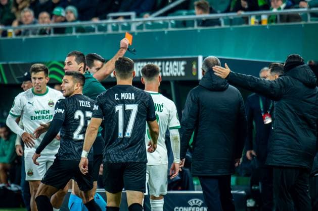 SOCCER - UEFA ECL, Rapid vs Craiova VIENNA,AUSTRIA,06.NOV.25 - SOCCER - UEFA Conference League, SK Rapid Wien vs CS Universitatea Craiova. Image shows Jonas Auer (Rapid), Samuel Teles, Carlos Mora (Craiova), Andrija Radulovic (Rapid) while referee Martin Matosa is showing a red card to a member of the bench of CS Universitatea Craiova.  GEPAxpictures xKevinxHackner