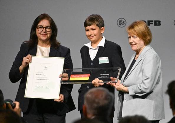 07 11 2025, xsltx, Fussball DFB Medientermine, DFB Bundestag v l Heike Ullrich DFB General Secretary , Leo Fitschen accepting the posthumous nomination of his mother Doris Fitschen as honorary captain of the DFB DFL DFB REGULATIONS PROHIBIT ANY USE OF PHOTOGRAPHS as IMAGE SEQUENCES and or QUASI VIDEO