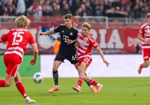 Duel between duel between Josip Stanisic FC Bayern Muenchen, 44 and Andras Schaefer FC Union Berlin, 13 08 11 2025, 1 FC Union Berlin FC Bayern München, Football, 1 Bundesliga in Berlin, Stadion an der Alten Försterei DFL regulations prohibit any use of photographs as image sequences and or quasi video Copyright: HMBxMedia xMarcoxBader