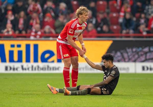 Leopold Querfeld FC Union Berlin, 14 hilt Luis Diaz FC Bayern Muenchen, 14 wieder hoch helps him back up 08 11 2025, 1 FC Union Berlin FC Bayern München, Fussball, 1 Bundesliga in Berlin, Stadion an der Alten Försterei DFL regulations prohibit any use of photographs as image sequences and or quasi video Copyright: HMBxMedia xMarcoxBader
