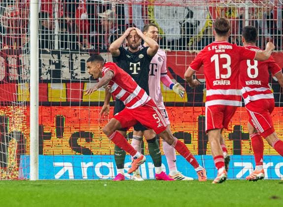 Soccer, Men, Season 2025 2026, 1 Bundesliga 10 Matchday , 1 FC Union Berlin FC Bayern Munich, f l Danilho Doekhi 1 FC Union Berlin , cheering after scoring 2 1, behind Harry Kane Bayern Munich disappointed, 08 11 2025, Copyright: xSebastianxRäppold MatthiasxKochx