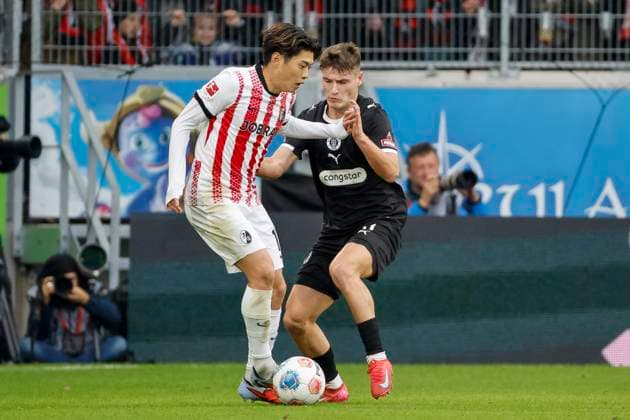 Yuito Suzuki SC Freiburg, 14 and Arkadiusz Pyrka FC St Pauli, 11 in duel , Germany, Soccer, 1 Bundesliga, Matchday 10, 2025 2026, SC Freiburg vs FC St Pauli, 09 11 2025, Europa Park Stadion, Freiburg im Breisgau, Germany Freiburg im Breisgau Europa Park Stadion Baden Württemberg Germany Copyright: xGrantxHubbsx