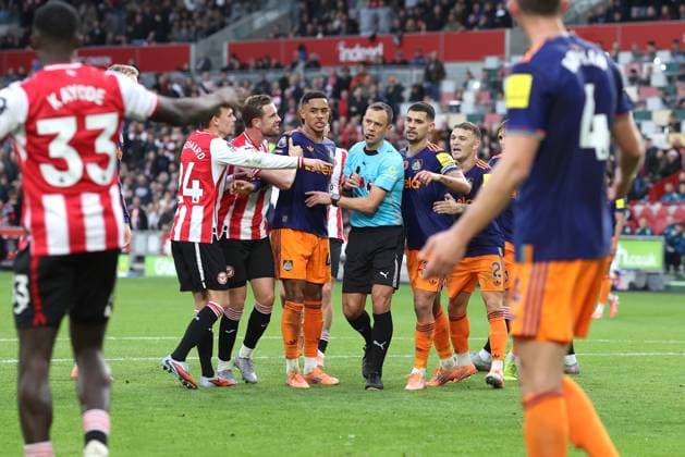 Brentford gegen Newcastle 09. November 2025, London Premier League Fußball Brentford gegen Newcastle United Die Spieler umringen Schiedsrichter Stuart Attwell, als er Dango Ouattara von Brentford die gelbe Karte für Tauchen zeigt Foto Charlotte Wilson Abseits London UK  Copyright: xCharlottexWilsonx xOffsidexOffside