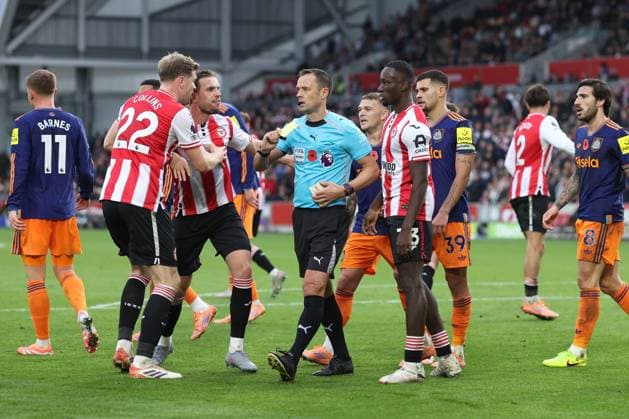 Brentford gegen Newcastle 09. November 2025, London Premier League Fußball Brentford gegen Newcastle United Die Spieler umringen Schiedsrichter Stuart Attwell, als er Dango Ouattara von Brentford die gelbe Karte für Tauchen zeigt Foto Charlotte Wilson Abseits London UK  Copyright: xCharlottexWilsonx xOffsidexOffside