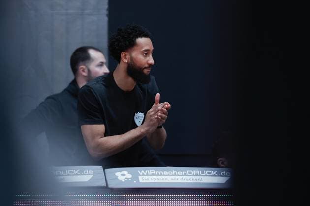 In the picture The injured Davion Mintz Wuerzburg Baskets, 10 cheers on his teammates 09 11 2025, Basketball, Fitness First Wuerzburg Baskets vs Rostock Seawolves, easyCredit BBL, Matchday 7, Germany, Wuerzburg, tectake Arena, Copyright: HMBxMedia xJulienxBecker