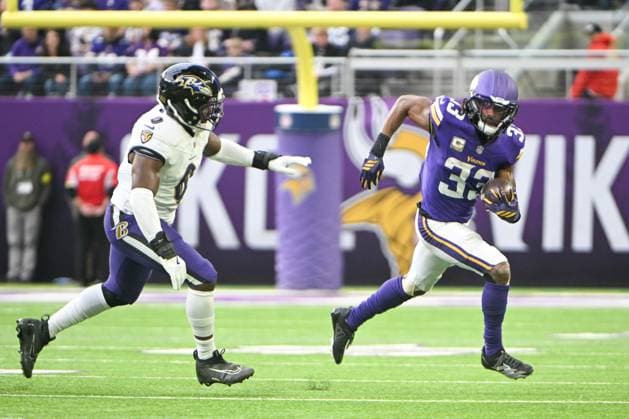 Minnesota Vikings running back Aaron Jones Sr. (R) runs past Baltimore Ravens linebacker Roquan Smith in the first quarter at U.S. Bank Stadium in Minneapolis, Minnesota on Sunday, November 9, 2025.  MIN20251109129 CRAIGxLASSIG