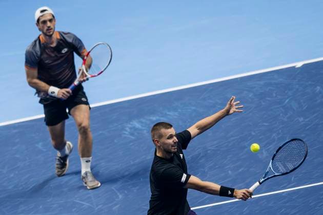 Nitto ATP, Tennis Herren Finals 2025 - Day One Lloyd Glasspool (bottom) of Great Britain plays a backhand next to Julian Cash of Great Britain during the round robin doubles match against Simone Bolelli and Andrea Vavassori of Italy during day one of the Nitto ATP Finals 2025. Simone Bolelli and Andrea Vavassori won 7-5, 6-3. Turin Italy Copyright: xNicolòxCampox