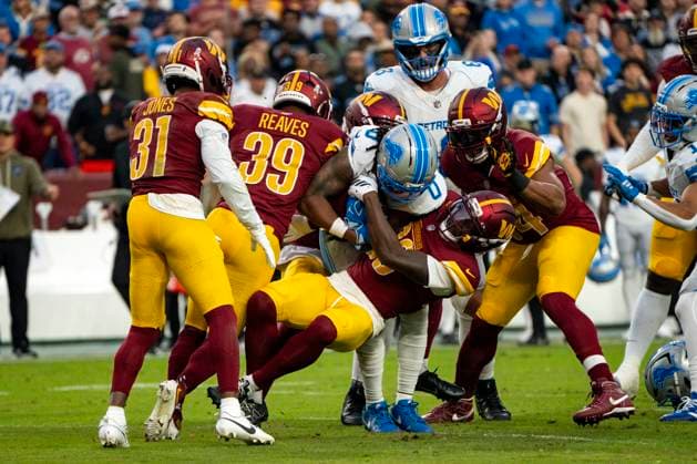 Detroit Lions running back Jahmyr Gibbs (0) is tackled by Washington Commanders safety Quan Martin (20) in the first quarter of a game at Northwest Stadium in Landover, Maryland on Sunday, November 9, 2025. The Lions beat the Commanders 44-22.  WAP20251109316 BONNIExCASH