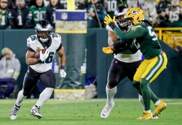 Philadelphia Eagles running back Saquon Barkley (L) runs the ball as Philadelphia Eagles offensive tackle Jordan Mailata (C) blocks Green Bay Packers defensive end Rashan Gary (R) in the first half of the NFL, American Football Herren, USA game between the Philadelphia Eagles and the Green Bay Packers at Lambeau Field in Green Bay, Wisconsin on Monday, November 10, 2025.  MIL20251110812 TANNENxMAURY