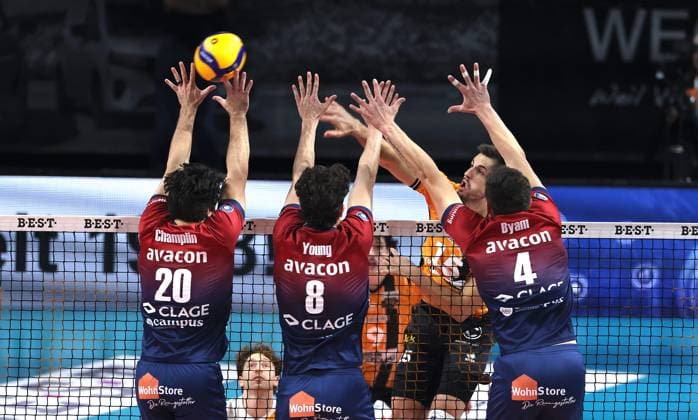 Moritz Reichert in attack, Ethan Champlin, Cole Young, Christopher Byam duel Match scene Action Sport Volleyball Bundesliga Men Season 2024 2026 12 11 2025 BR Volleys Berlin BRV vs SVG Lüneburg