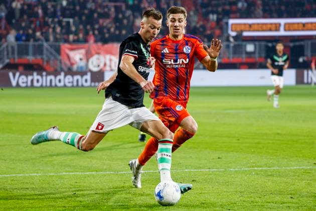 Arno Verschueren of FC Twente passes the ball under pressure from Felipe Sanchez of Schalke 04 FC Twente v FC Schalke 04, 60th Anniversary Game, FC Twente v Schalke 04, De Grolsch Veste Stadium, November 13, 2025, Enschede, Netherlands.