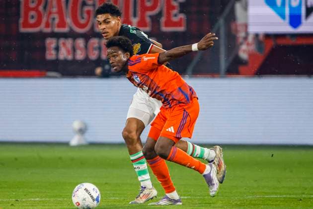 Clint Wilson of Schalke 04 dribbles with the ball under pressure from Bjorn Titulaer of FC Twente FC Twente v FC Schalke 04, 60th Anniversary Game, FC Twente v Schalke 04, De Grolsch Veste Stadium, November 13, 2025, Enschede, Netherlands.