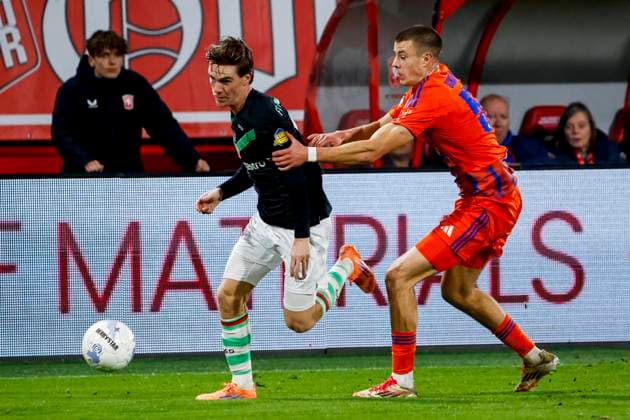 Daan Rots of FC Twente dribbles with the ball under pressure from Magnus Rosner of Schalke 04 FC Twente v FC Schalke 04, 60th Anniversary Game, FC Twente v Schalke 04, De Grolsch Veste Stadium, November 13, 2025, Enschede, Netherlands.