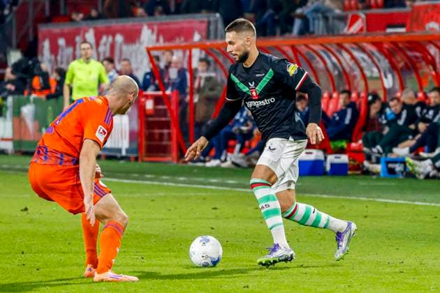 Marko Pjaca of FC Twente dribbles with the ball under pressure from Henning Matriciani of Schalke 04 FC Twente v FC Schalke 04, 60th Anniversary Game, FC Twente v Schalke 04, De Grolsch Veste Stadium, November 13, 2025, Enschede, Netherlands.