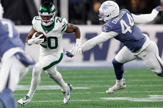 New York Jets running back Breece Hall, left, breaks from New England Patriots linebacker K Lavon Chaisson, right, during the first half at Gillette Stadium in Foxborough, Massachusetts on 13, November 13, 2025.  BOP20251113004 CJxGUNTHER
