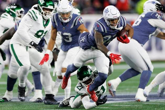 New England Patriots running back TreVeyon Henderson, right, breaks the tackle of New York Jets cornerback Brandon Stephens, left, during the first half at Gillette Stadium in Foxborough, Massachusetts on Thursday, November 13, 2025.  BOP20251113009 CJxGUNTHER