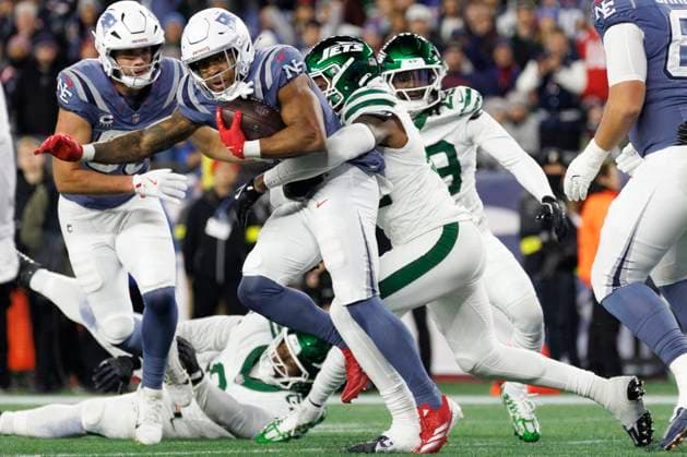 New England Patriots running back TreVeyon Henderson, left, breaks the tackle of New York Jets linebacker Jamien Sherwood, right, during the first half at Gillette Stadium in Foxborough, Massachusetts on Thursday, November 13, 2025.  BOP20251113013 CJxGUNTHER