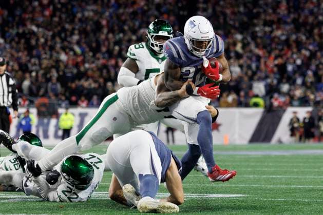 New England Patriots running back TreVeyon Henderson, right, breaks the tackle of New York Jets defensive tackle Jay Tufele, left, during the second half at Gillette Stadium in Foxborough, Massachusetts on Thursday, November 13, 2025.  BOP20251113022 CJxGUNTHER