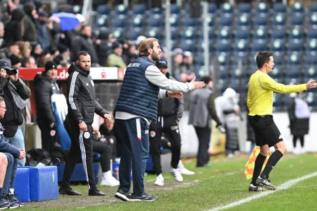 Ronny Ermel 999 SV Babelsberg 03 gives instructions on the touchline while Claus Dieter Wollitz 999 FC Energie Cottbus and Nico Hinz 998 SV Babelsberg 03 stand in the background The referee directs the match Coach on the touchline Copyright: xSpeedshotx