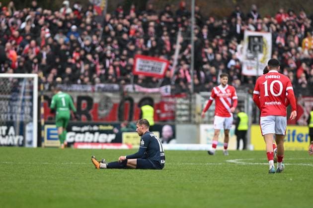 Tino Schmidt 11 SV Babelsberg 03 sits injured on the ground while Tolcay Cigerci 10 FC Energie Cottbus and other FC Energie Cottbus players walk past Player sits injured Copyright: xSpeedshotx