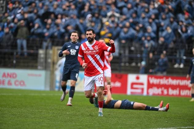Tolcay Cigerci 10 FC Energie Cottbus with the ball in action while Nils Schätzle 8 SV Babelsberg 03 defends and another player is on the ground Player in action on the pitch Copyright: xSpeedshotx