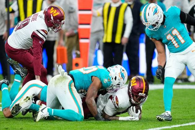 November 16, 2025, Madrid, Madrid, Spain: Chris Rodriguez Jr. of the Washington Commanders and Jordyn Brooks of the Miami Dolphins compete for the ball during the National Football League NFL, American Football Herren, USA 2025 Madrid Game, match played between Miami Dolphins and Washington Commanders at Bernabeu stadium on November 16, 2025, in Madrid, Spain. Madrid Spain - ZUMAa181 20251116_zaa_a181_082 Copyright: xOscarxJ.xBarrosox