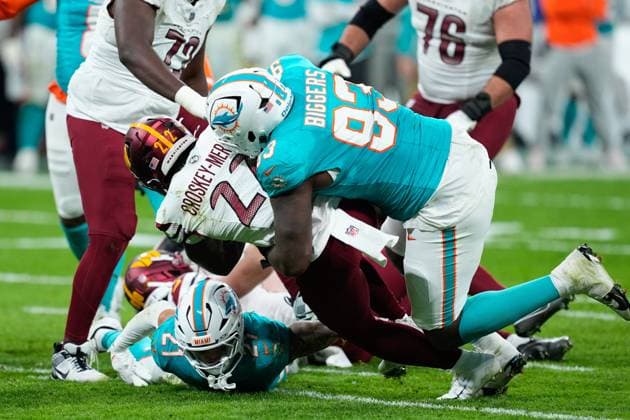 November 16, 2025, Madrid, Madrid, Spain: Jacory Croskey-Merritt of the Washington Commanders and Zeek Biggers of the Miami Dolphins compete for the ball during the National Football League NFL, American Football Herren, USA 2025 Madrid Game, match played between Miami Dolphins and Washington Commanders at Bernabeu stadium on November 16, 2025, in Madrid, Spain. Madrid Spain - ZUMAa181 20251116_zaa_a181_188 Copyright: xOscarxJ.xBarrosox