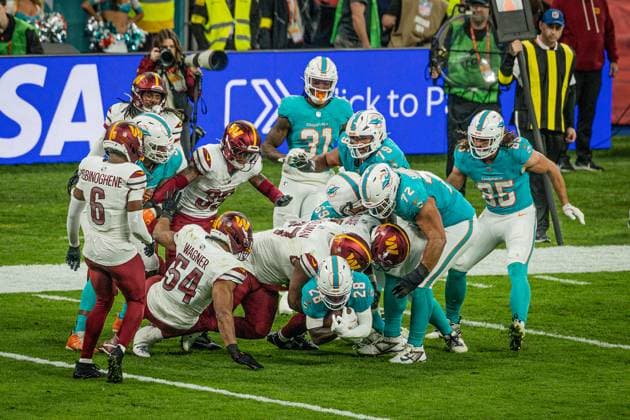 De Von Achane (Miami Dolphins, 28) brought down with the ball in his arms, Miami Dolphins vs Washington Commanders, American Football, National Football League, Season 2025, Week 11, 16.11.2025, Madrid Estadio Bernabeu Spain Copyright: xFootxBowl ThomasxMummertx